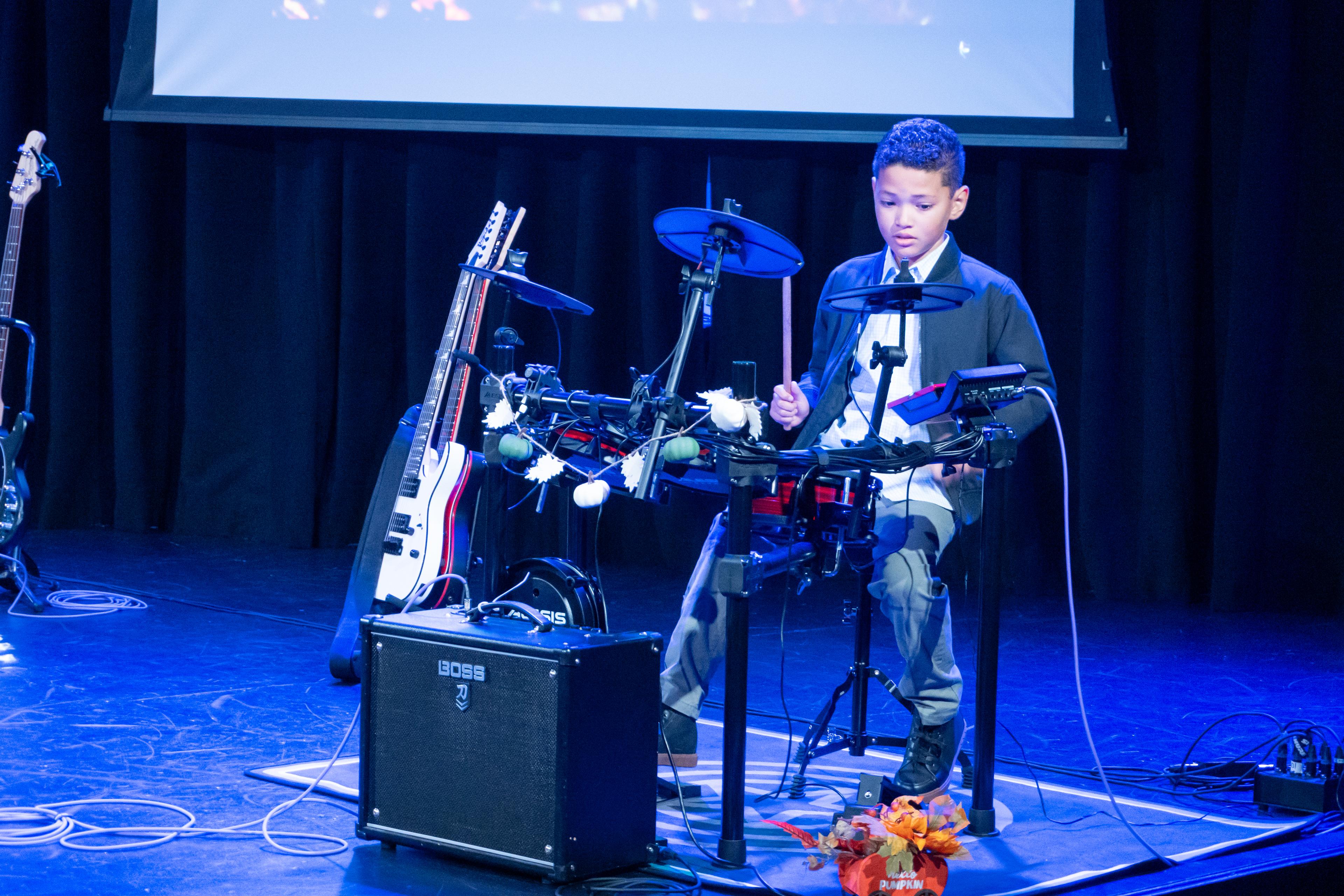 Student performing on electronic drums at recital