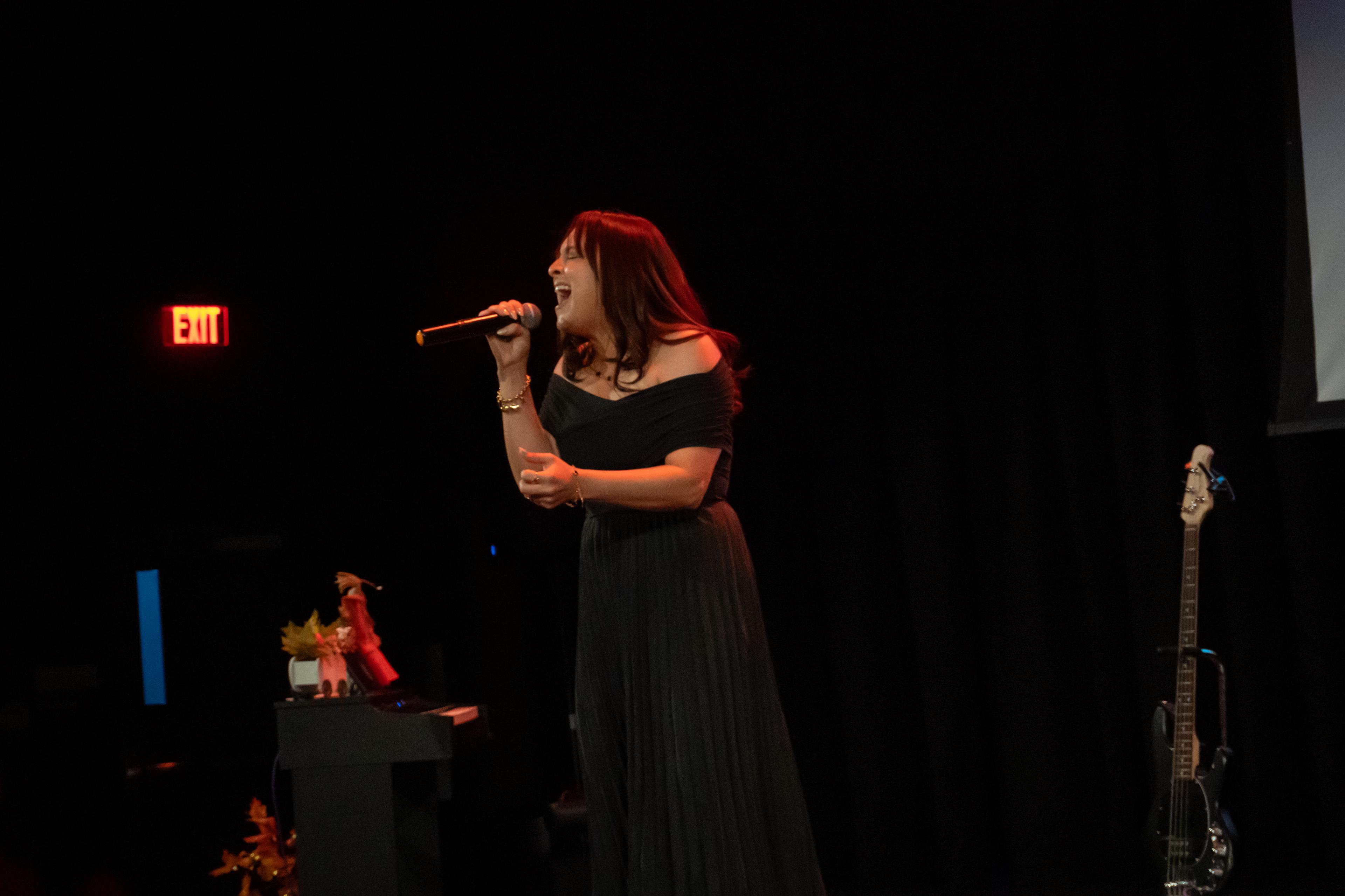 Woman singing passionately at recital on stage
