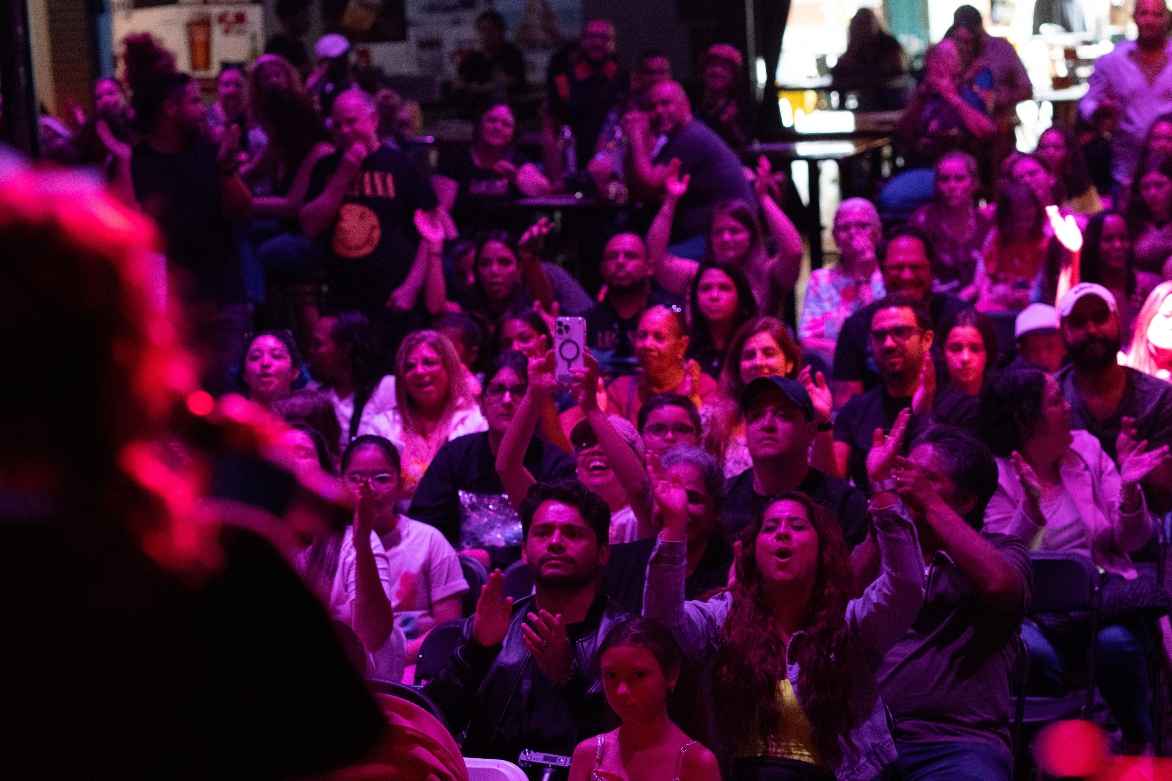 Familias aplaudiendo en un concierto de The World of Music