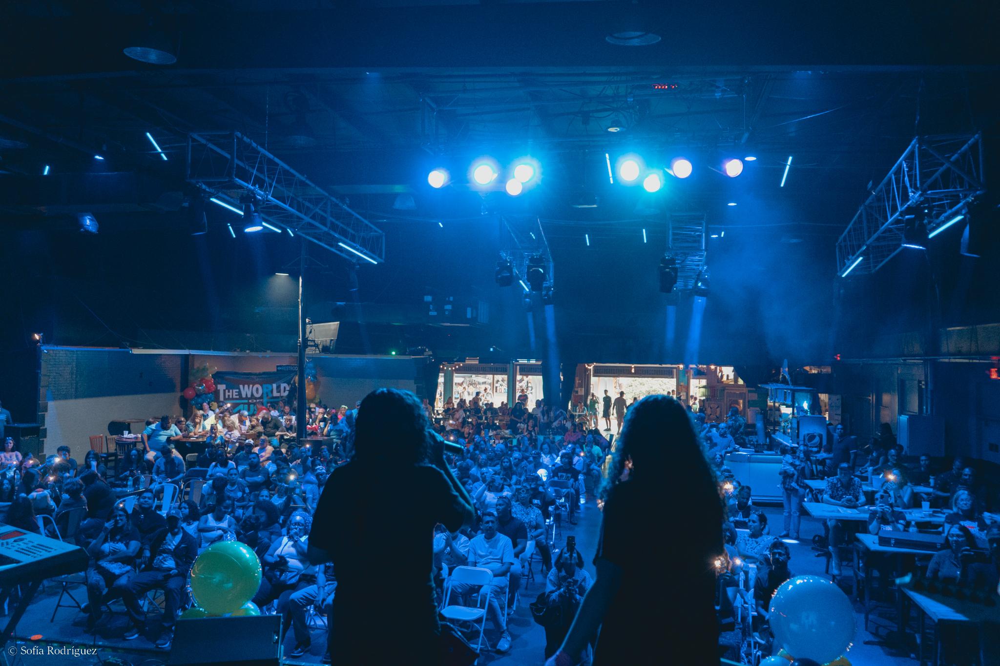 Audiencia llena en concierto bajo luces azules