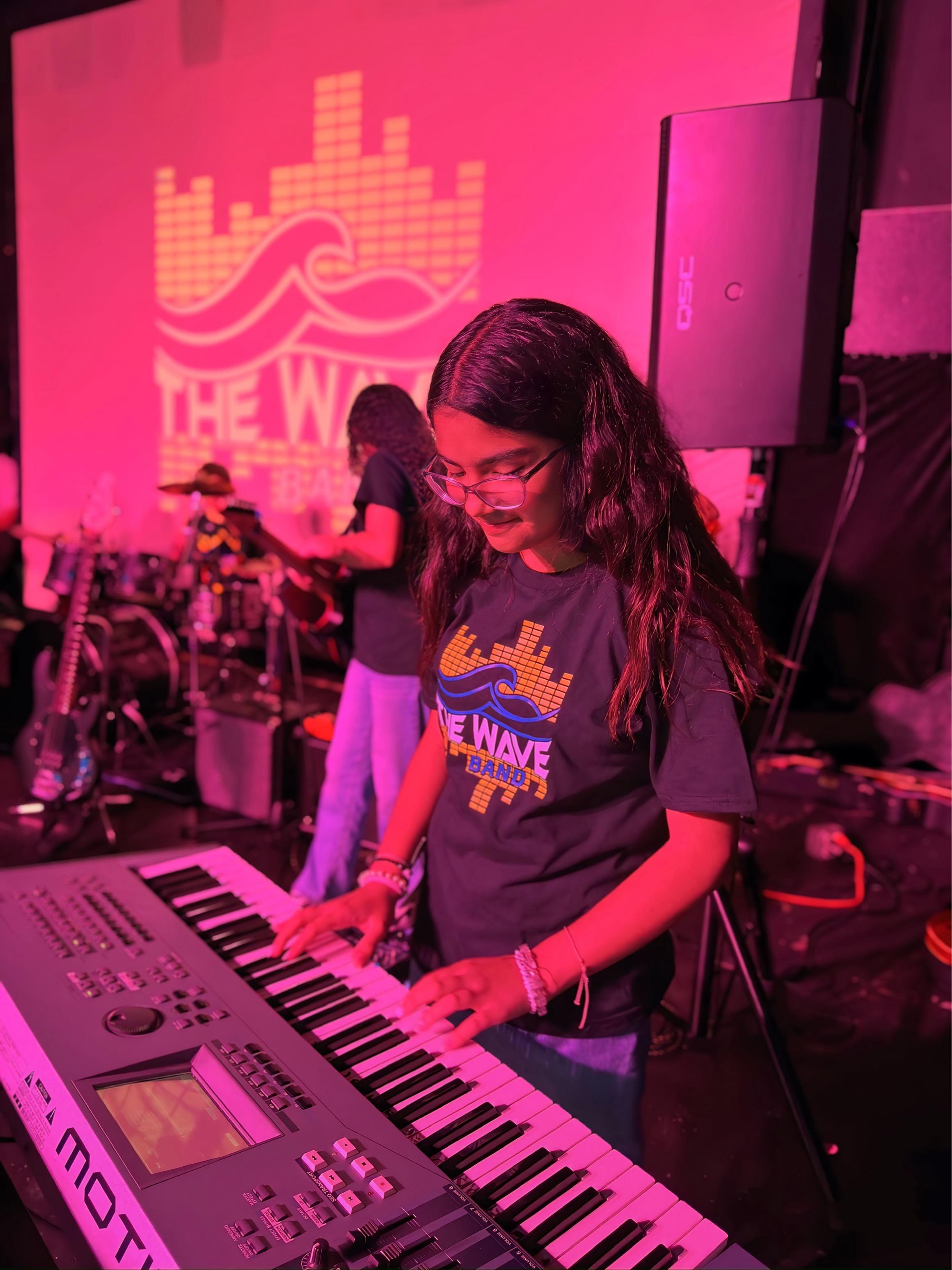 Tecladista actuando bajo luces rosas